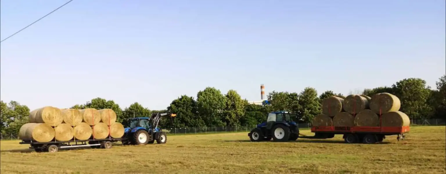 Zwei Traktoren mit Anhänger voller Heuballen auf dem Feld – Heuernte und Landwirtschaft am Matzerhof